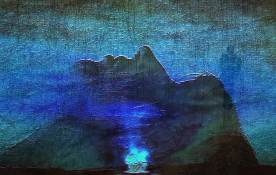 A blue dreamlike image of a resting face and mountain forms