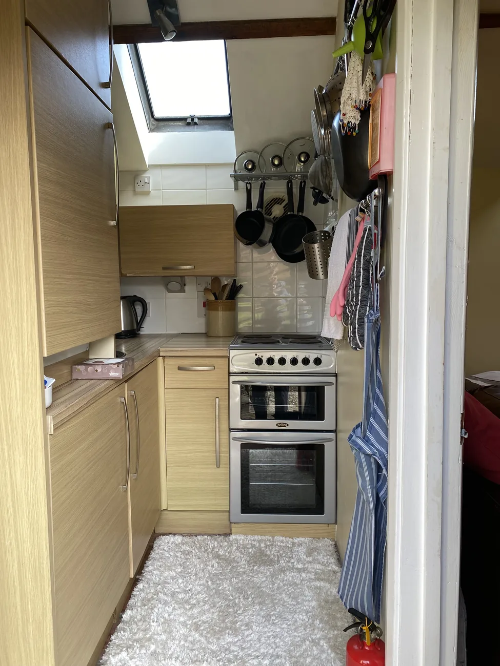 The compact self-catering kitchen with a cooker inside the retreat cottage